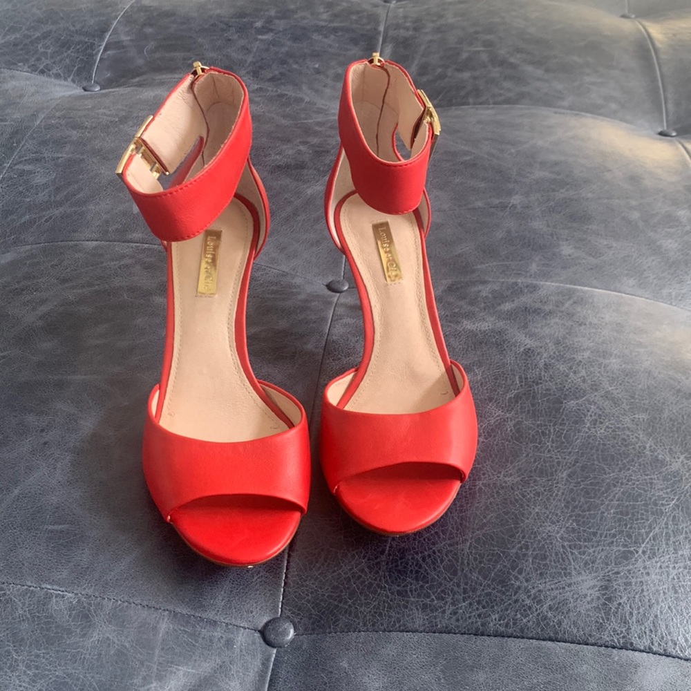 Red dress sandals with brass buckle and zipper.